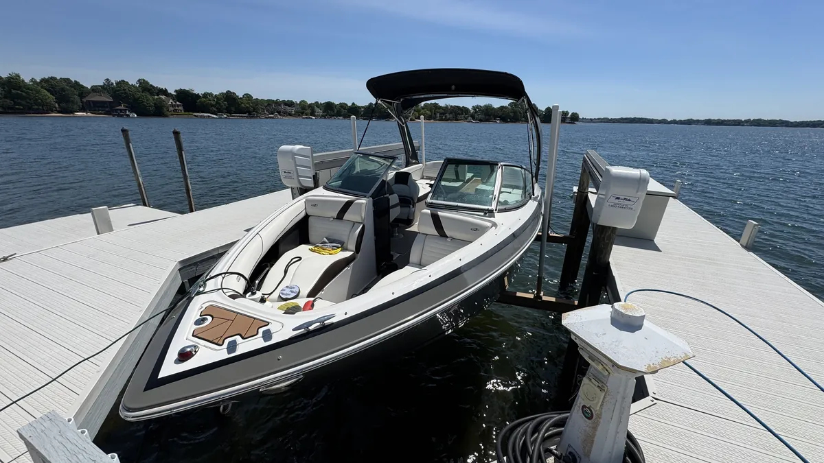 Clean wake boat bow and seating on its lift, with open Lake Norman water behind